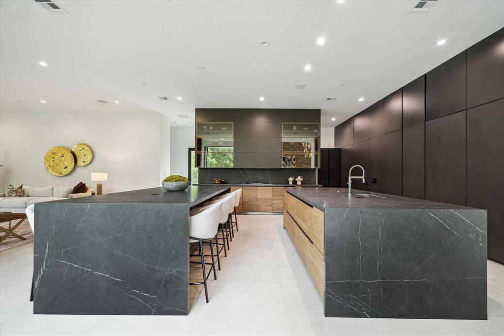 Tucked behind the kitchen, custom Poliform cabinetry with integrated backlighting offers elegant pantry storage and houses the ovens, combining functionality with sophisticated design.