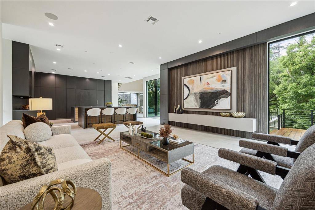 A wall-mounted television with custom color-changing backlighting sets the perfect mood for movie nights, adding a dynamic and immersive touch to the family room experience.