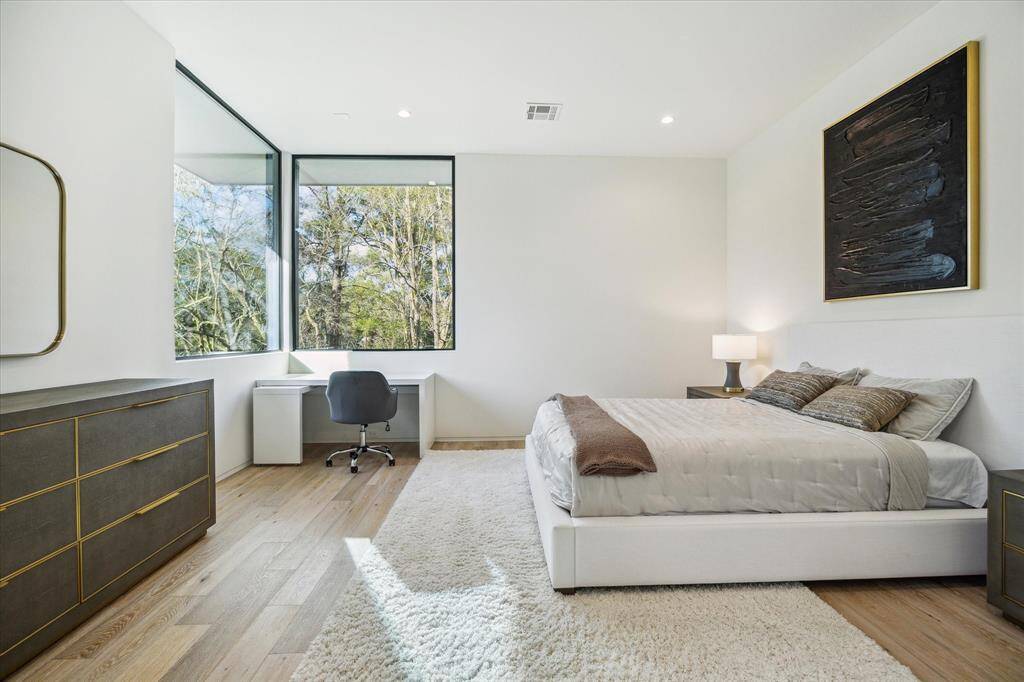 Guest Bedroom #1 (16'1" x 14'1") features elegant Maxwell White Oak hardwood flooring and large windows that overlook the peaceful backyard. The room includes a custom Poliform Senzafine closet, offering ample storage, and is complemented by its own ensuite bathroom for added privacy and convenience.