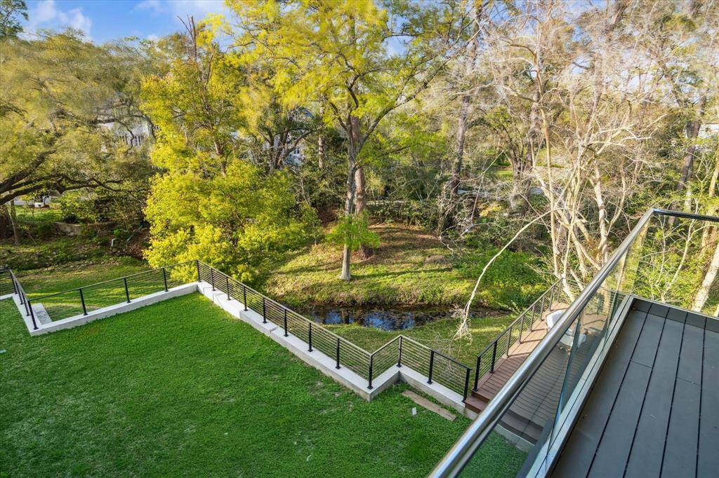 The backyard offers serene tree-lined views, providing a peaceful retreat with ample space for a future pool, allowing for endless possibilities to create your own private oasis.