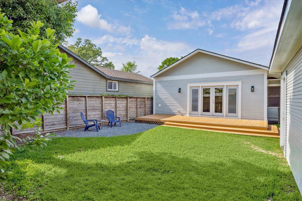 Framed by a privacy fence and mature landscaping, the seating area is the perfect corner for outdoor lounging under the trees or fireside chats with friends.