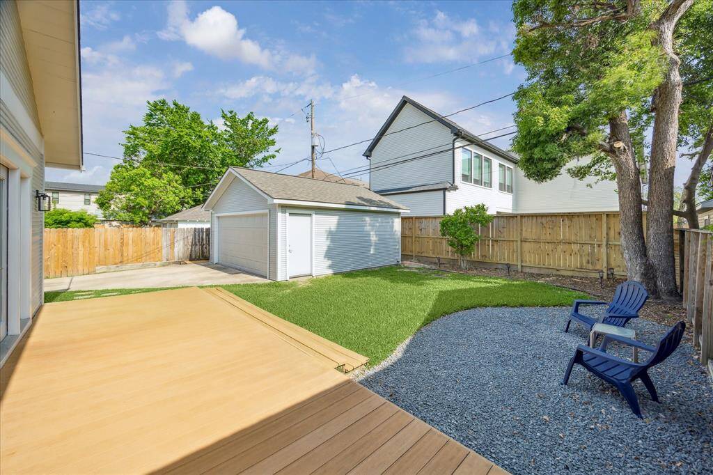 This view highlights the thoughtful layout: a generous deck steps down into a grassy yard, creating a balance of entertaining space and play area.