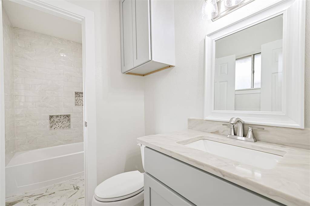 primary half bath with doorway to tub/shower