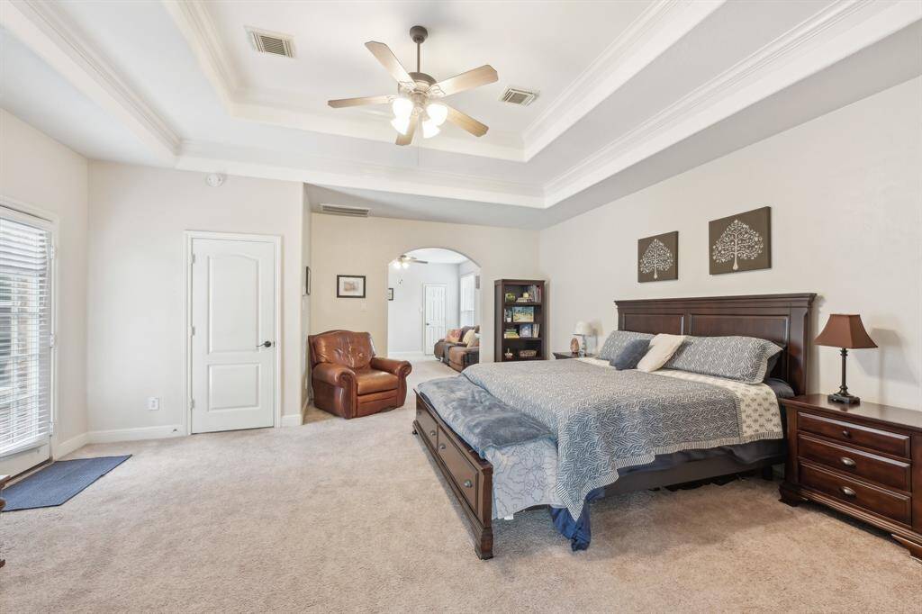Primary bedroom w/double tray ceilings, access to back patio & extra suite attached