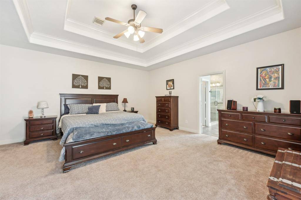 Primary bedroom w/double tray ceilings, access to back patio & extra suite attached
