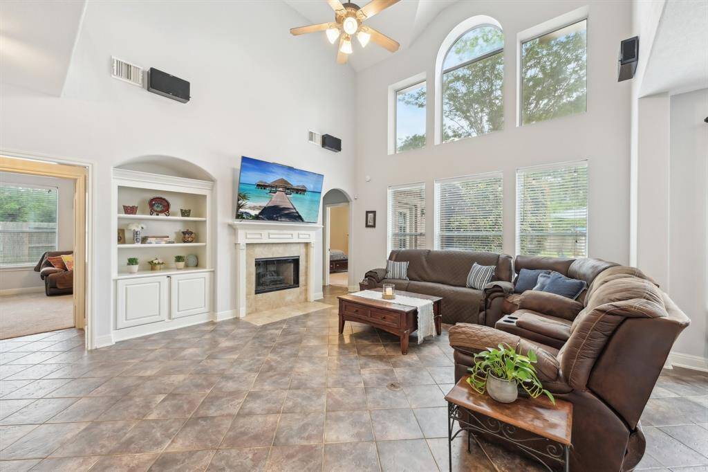 Family room with 2 story ceilings & wall of windows for natural light & views of backyard oasis!