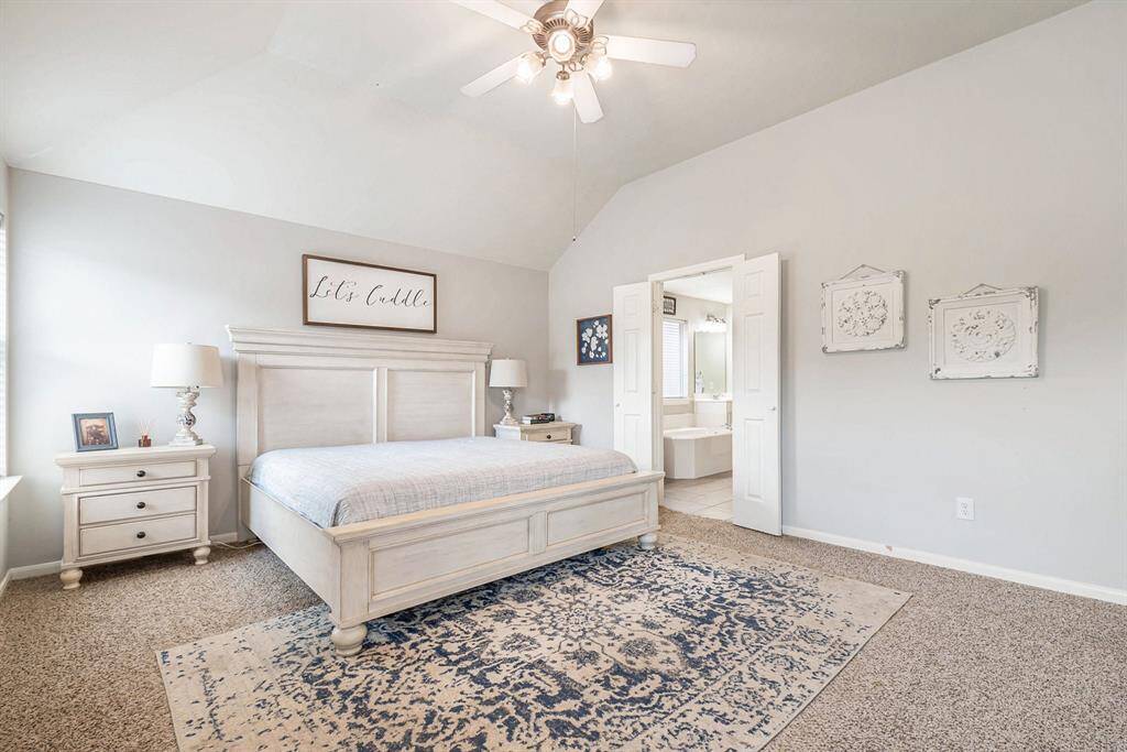 Gorgeous primary bedroom showcases high ceilings, overlooks the backyard, and a lavish en suit.