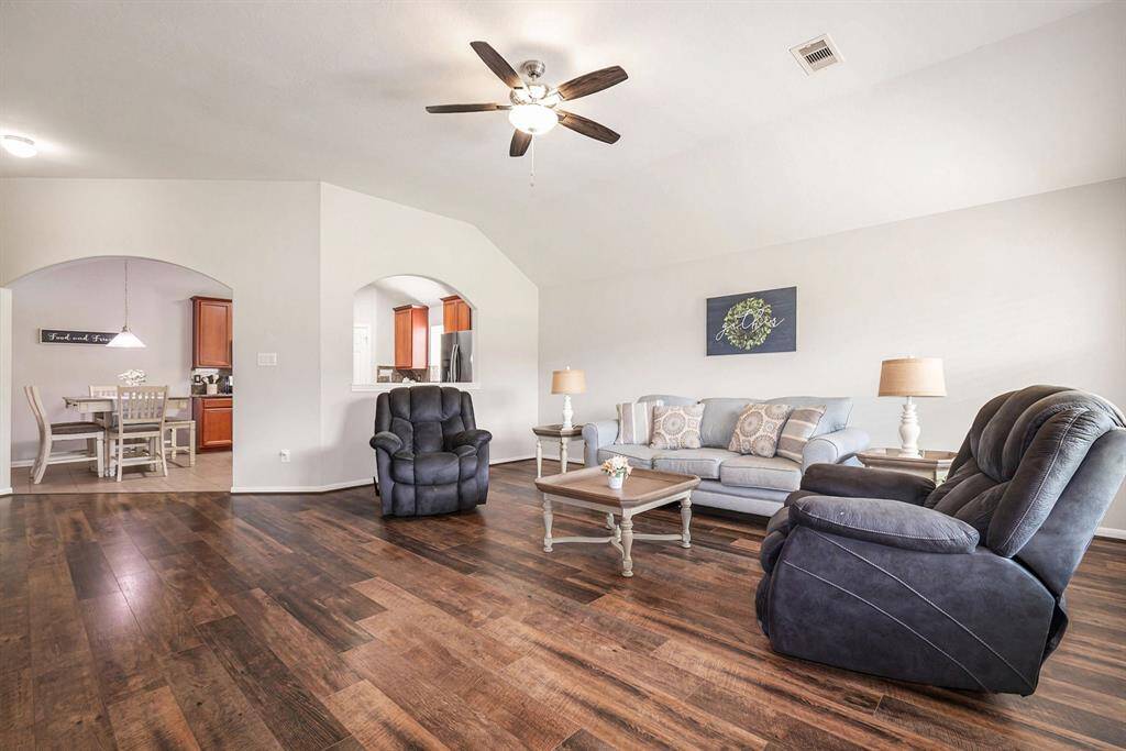 Spacious living room presents high ceilings and seamlessly flows into the kitchen.