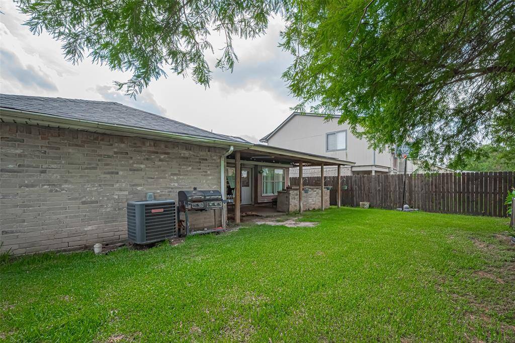 Spacious backyard featuring a covered patio, perfect for outdoor gatherings. The area is fenced for privacy, with well-maintained grass and mature trees providing shade. Ideal for relaxation and entertaining. NO backyard neighboors.