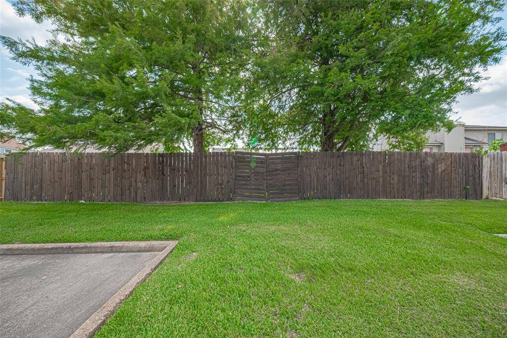 Double wooden fence door opens to store larger equipment in the backyard.