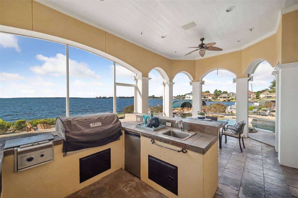Outdoor Kitchen with grill, "crawfish" burners, sink & mini fridge plus service counter with barstool seating.