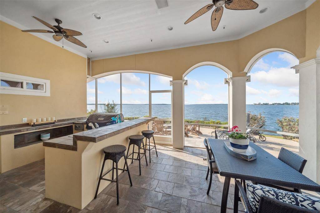 Outdoor dining area with amazing views from this screened in porch.  Pool Bath is located to the left of the Outdoor Kitchen (out of photo view).