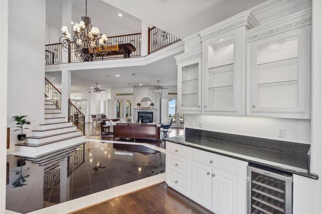 View to the Living Room & Gameroom above from the Dining Room with serving counter, glass front hutch & beverage cooler.
