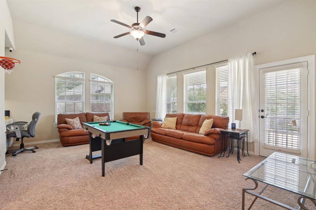 The game room includes a door that opens to a balcony overlooking the front of the home, providing a perfect spot to relax and enjoy the neighborhood view.