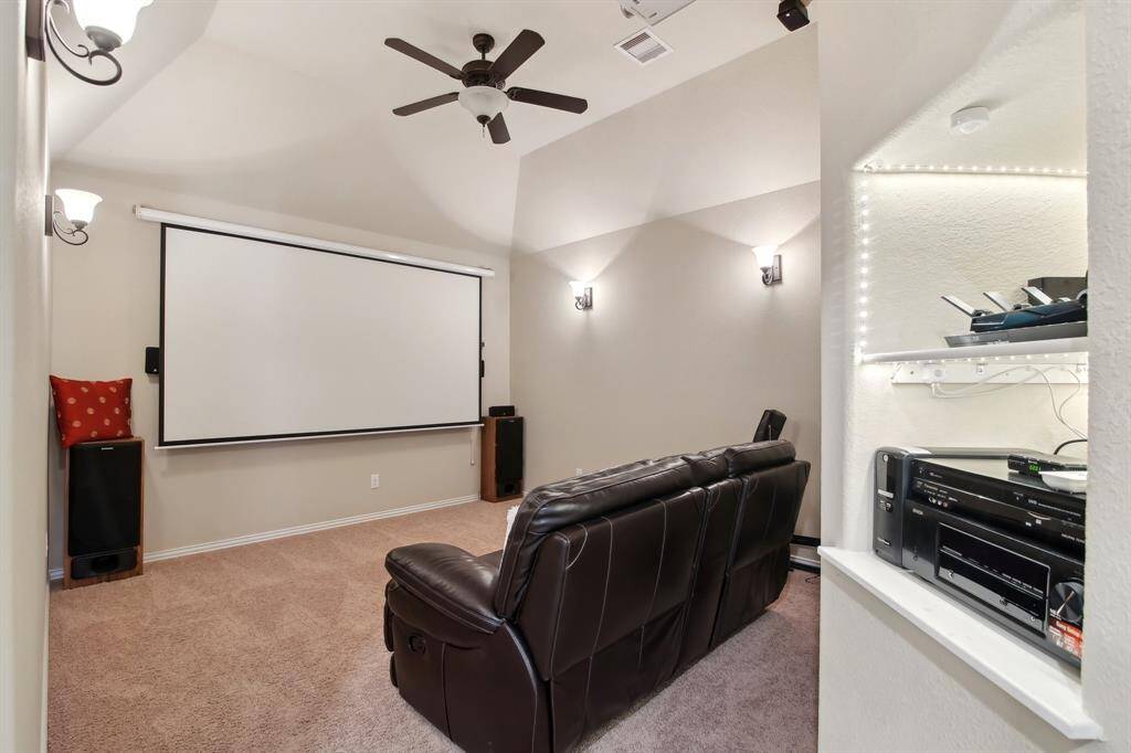 To the left of the game room, discover a dedicated media room equipped with built-in lighting and a large screen — perfect for movie nights and immersive entertainment.