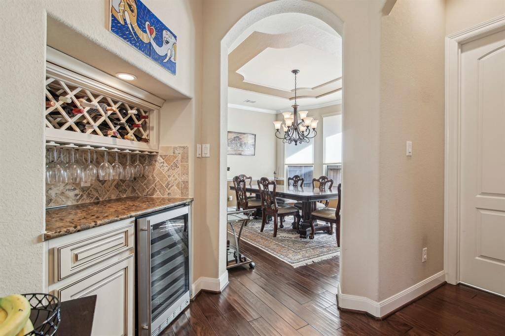 Elegant butler’s wine bar tucked between the kitchen and dining room, complete with a built-in wine fridge and custom cabinetry — perfect for entertaining and storing your favorite vintages.