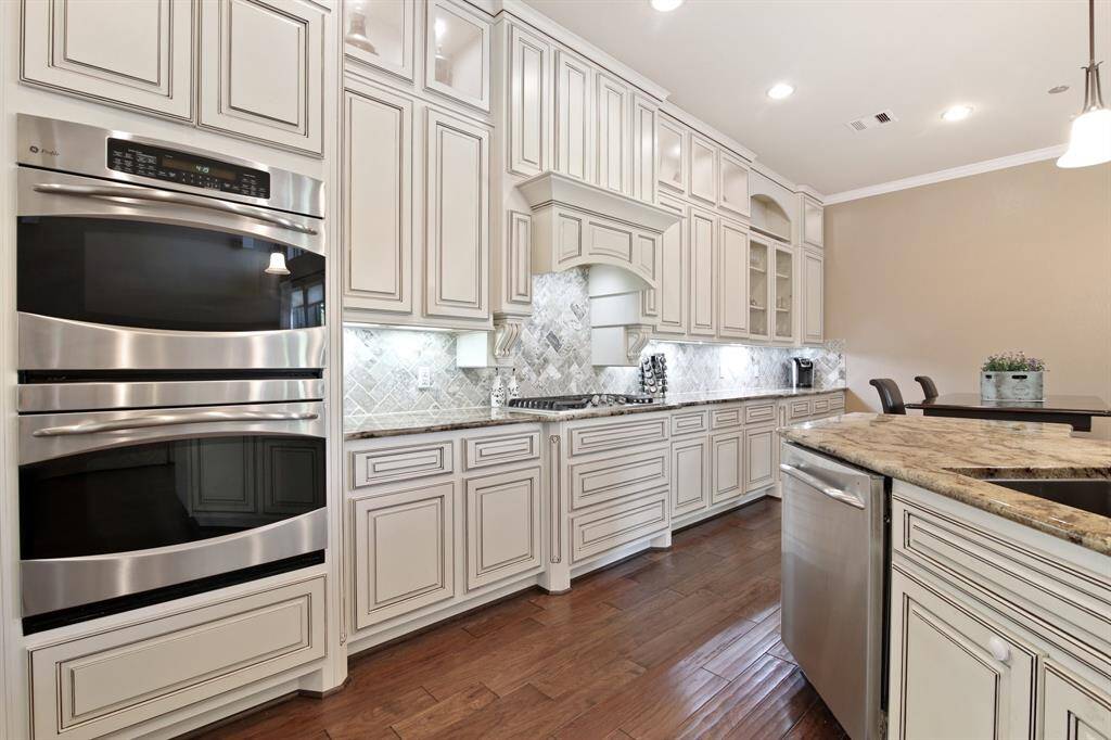Gourmet kitchen designed for both function and style, featuring double ovens, custom cabinetry, and sleek granite countertops. A true centerpiece of the home, perfect for home chefs and entertaining alike.