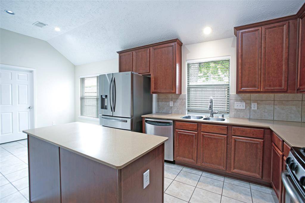 Your dream kitchen is ready to impress! Beautiful cabinets are paired with sleek Silestone countertops and a stylish tile backsplash, complete with a convenient elevated breakfast bar and a spacious island.