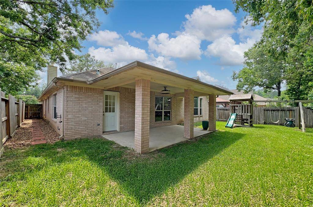 The extended covered patio offers ample space for comfortable outdoor living and entertaining.