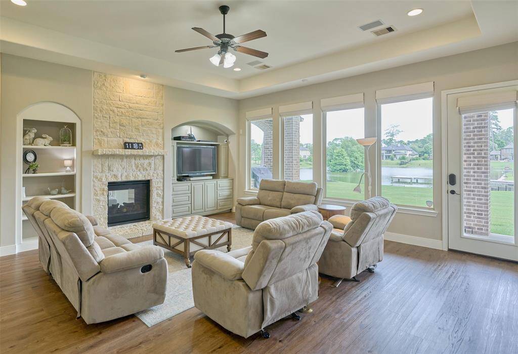 Inviting family room with a cozy fireplace, ample natural light, and stunning lake views—ideal for relaxation and gatherings.