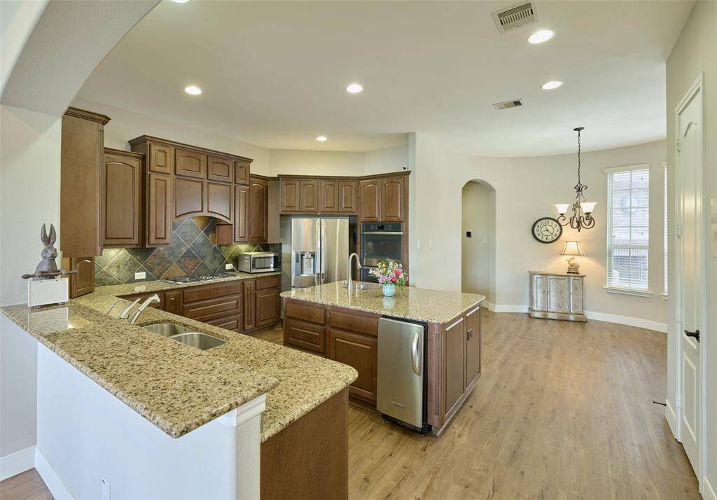Stunning kitchen with granite countertops, custom cabinets, and stainless steel appliances—ideal for any chef. Includes an ice maker with gravity drain.