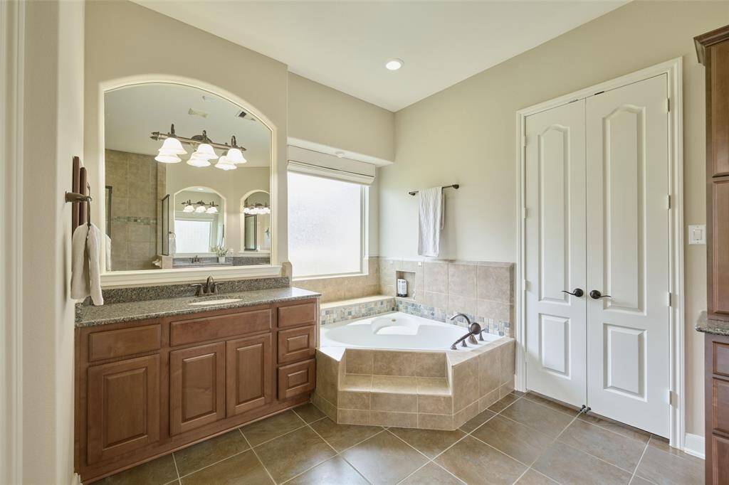 Abundant natural light fills this inviting space, featuring a spacious step-up bath and a generously sized closet with discreet storage for valuables.