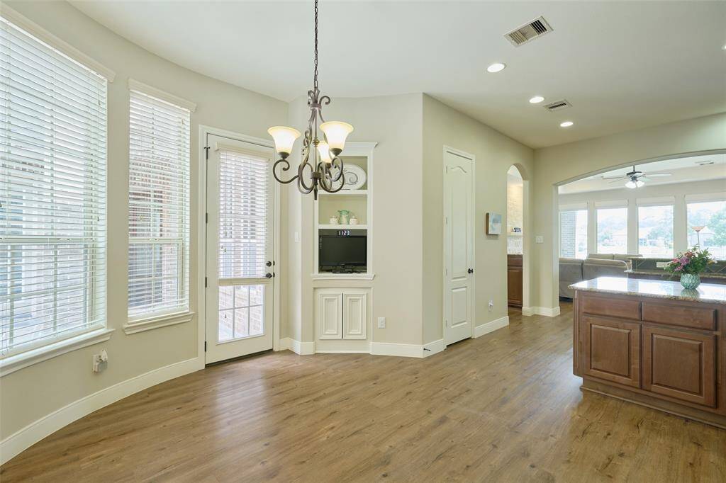 Bright breakfast nook with elegant lighting, abundant natural light from large windows, and convenient courtyard access—perfect for morning coffee.