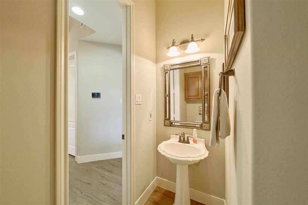 Elegant powder room by the garage entrance with stylish fixtures and timeless design.