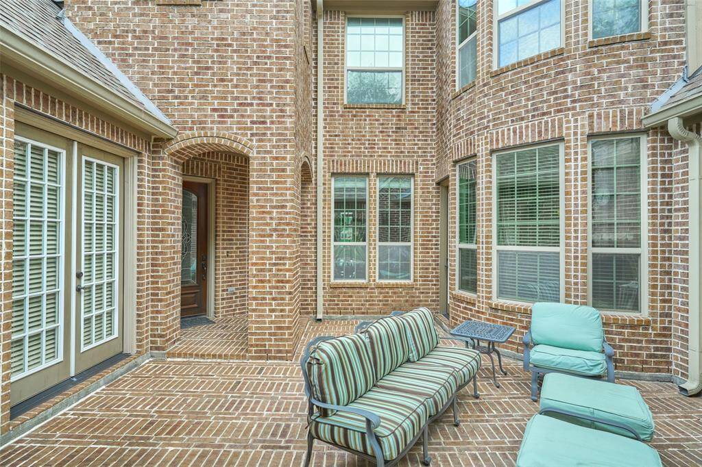 This bright space, surrounded by large windows, offers a welcoming outdoor retreat.