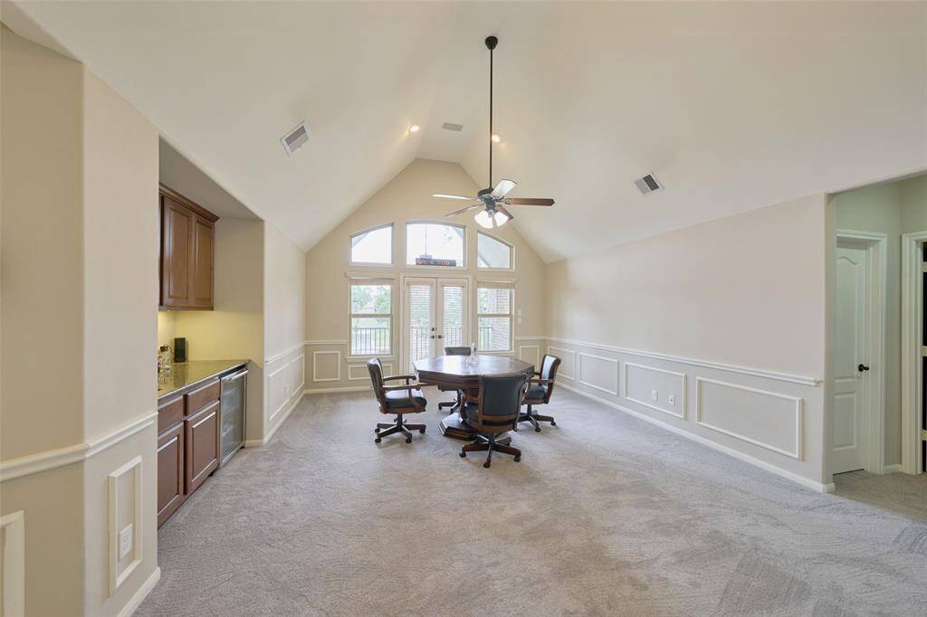 Expansive game room with soaring ceilings and private balcony access.