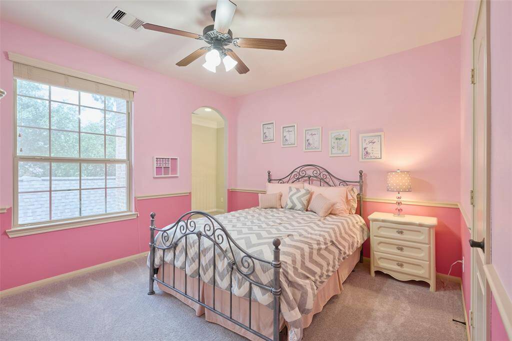 Bedroom 4 offers a cozy retreat with soft pink walls, abundant natural light, and charming decor, creating a welcoming and vibrant space.