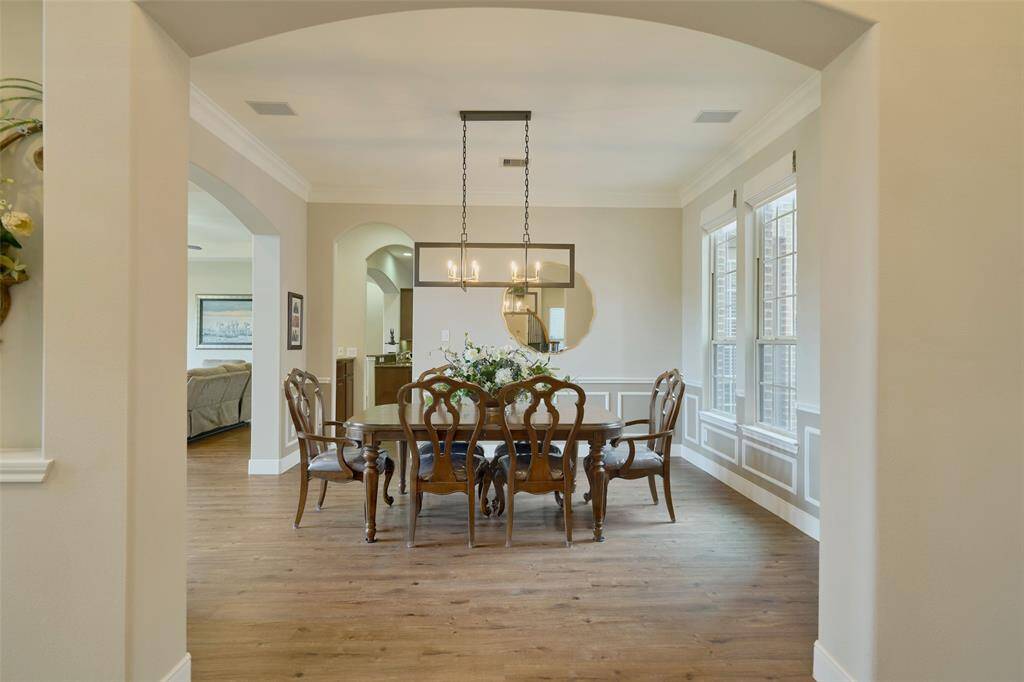 Charming dining room with warm floors, natural light, and a chic chandelier—ideal for entertaining.