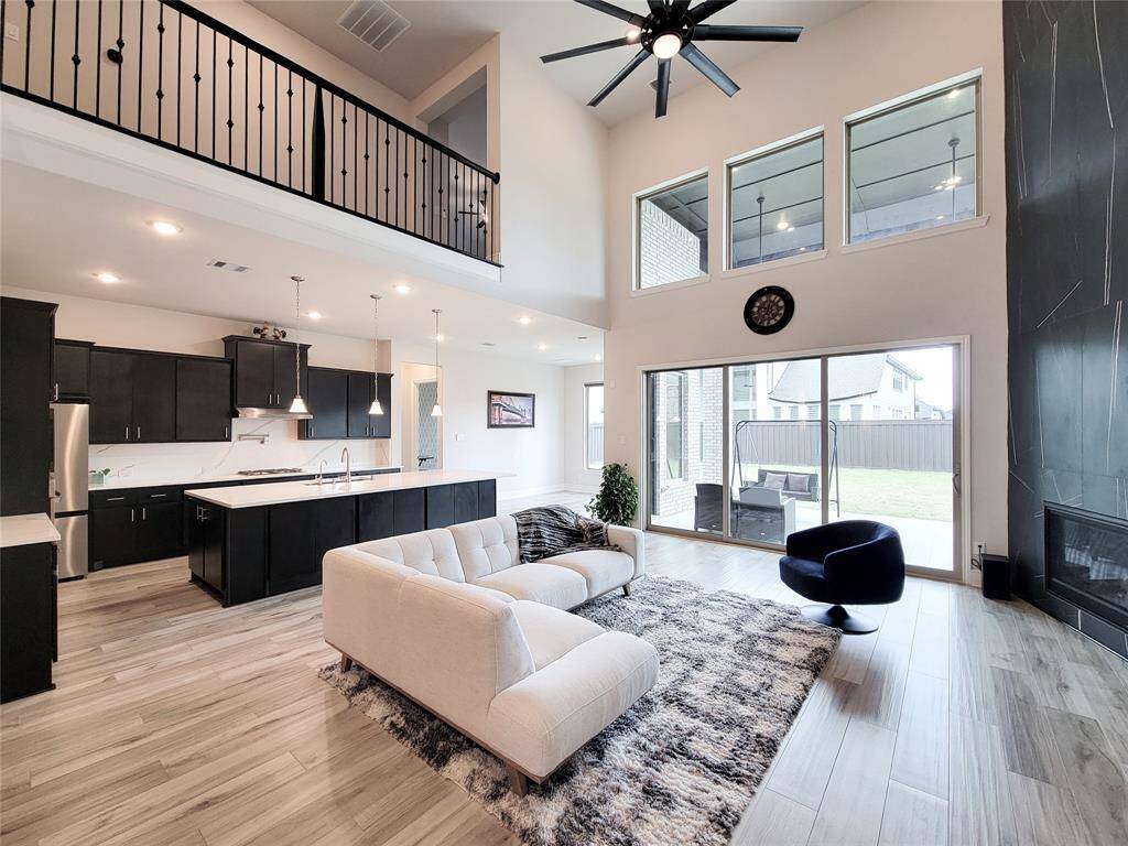 Huge & spacious Living /Family room with tall two-story high ceilings & three paneled sliding door leading to covered patio/backyard.