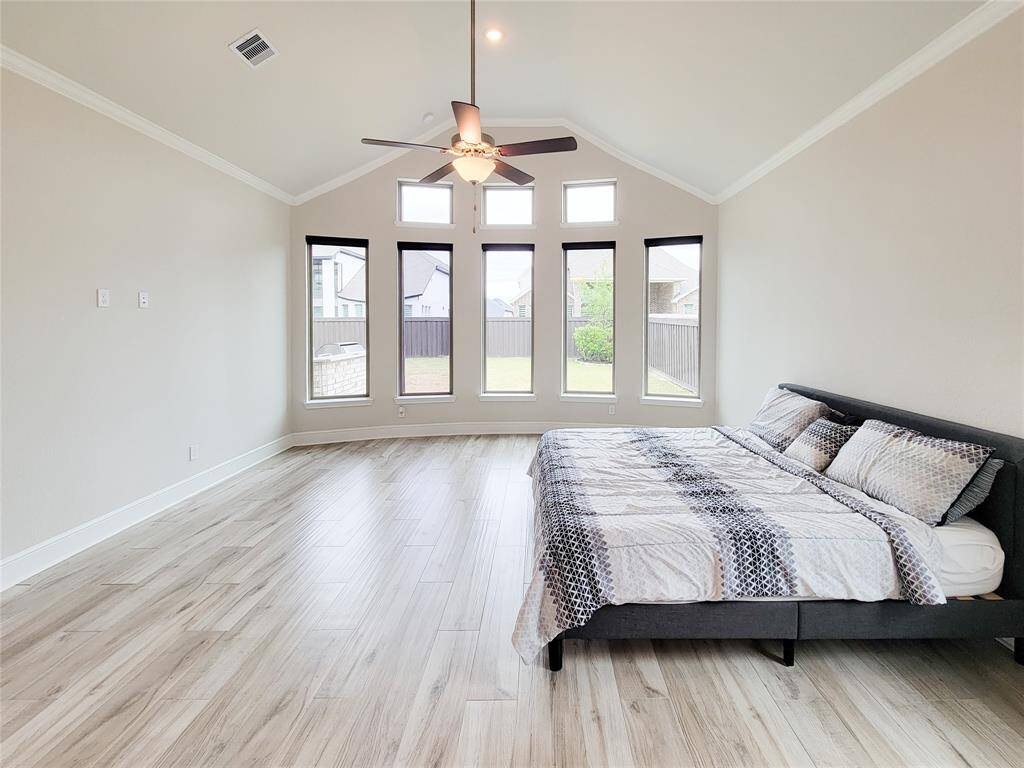 Spacious Primary suite with crown molding, sitting area & Bay windows & barn door leading to the bathroom.