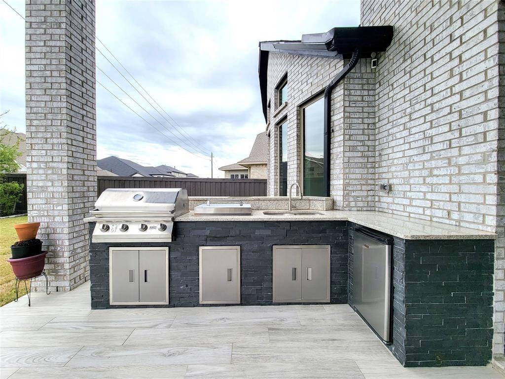Out-door Kitchen all equipped with stove, grill & even comes with a mini fridge.