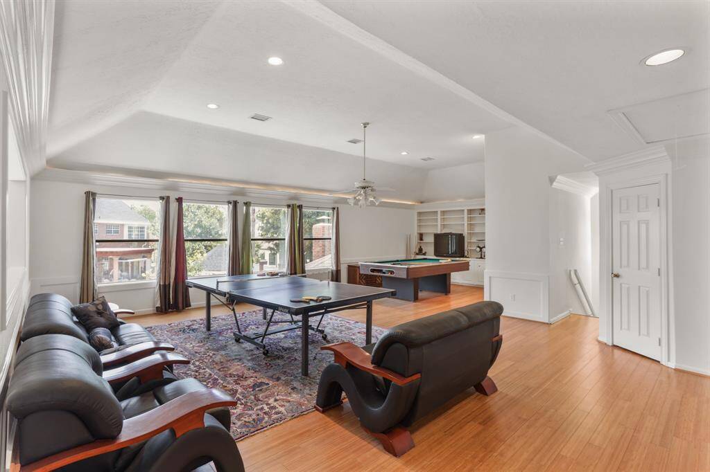 Upstairs is this large Game Room or Sports area for all the family, custom rope lightning, Bamboo floors and plenty of natural light featuring the second wet bar in this home offering a great entertainment area for the young and old.