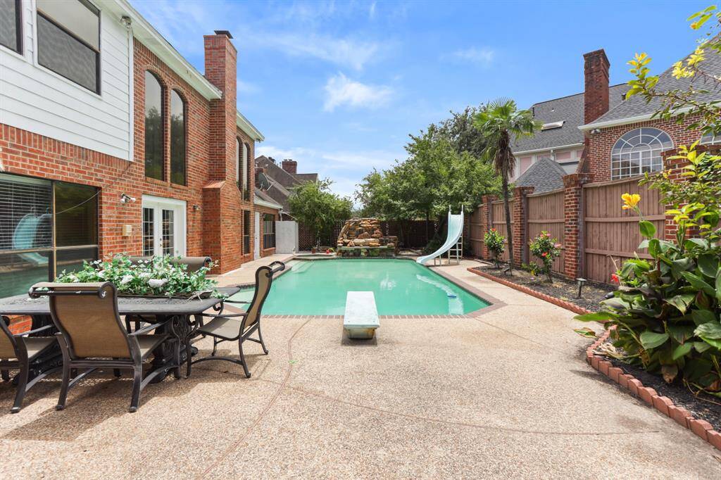 Outside has a wonderful pool with slide, diving board and custom natural rock waterfall.