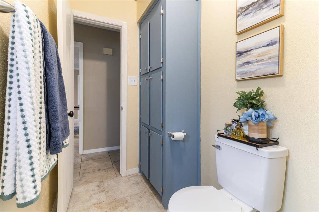 This full bathroom offers functionality with a walk-in shower, tile flooring, and a window that brings in soft natural light.