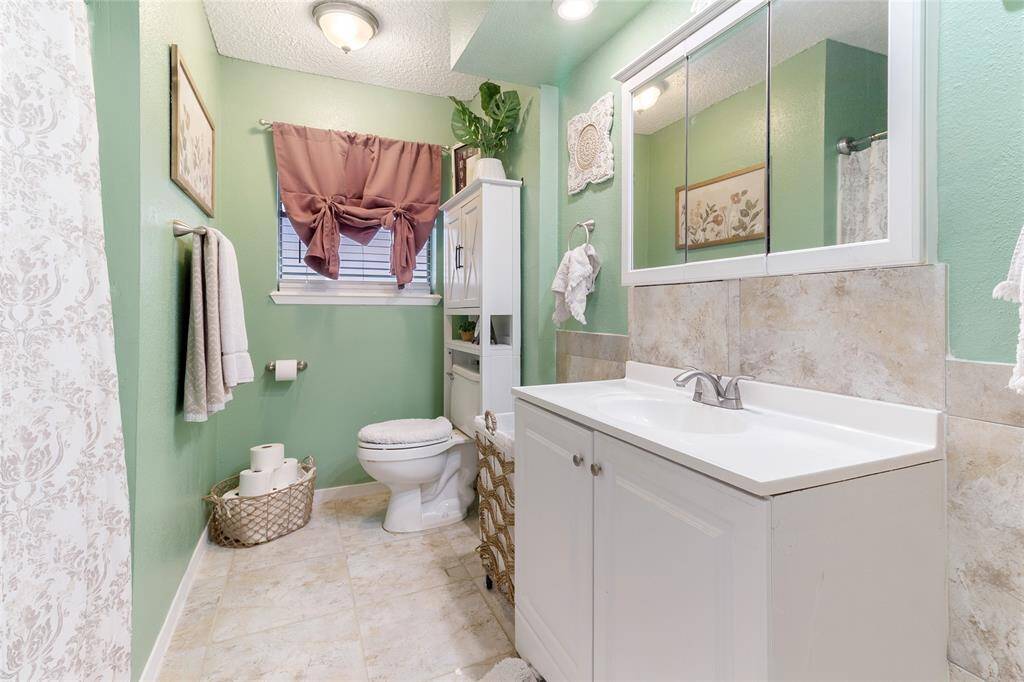 Secondary bedroom (13x10) featuring two large windows that flood the space with natural sunlight & easy-to-maintain tile flooring — a functional space perfect for kids, guests, or home office.