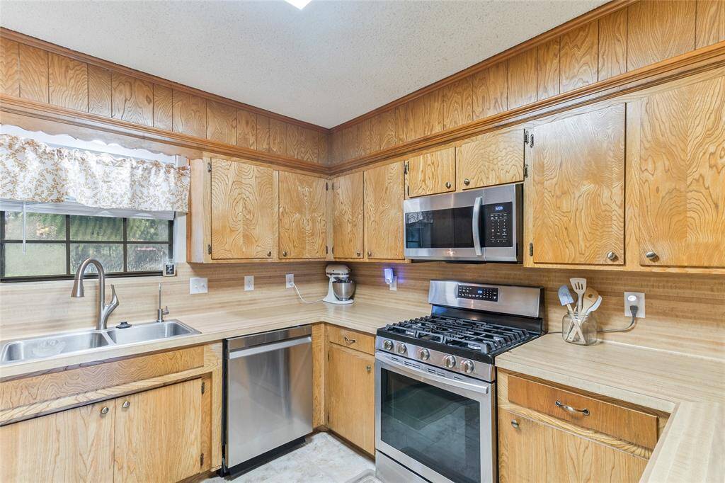 Spacious and homey, the family room (27x12) offers a sliding glass door filling the space with natural light & offers easy access to the covered patio and backyard — ideal for indoor-outdoor living.