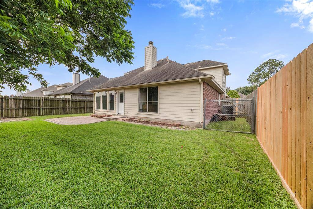 Charming backyard with a well-maintained lawn, a spacious patio area, and a fenced perimeter for privacy. Great for outdoor activities and relaxation.