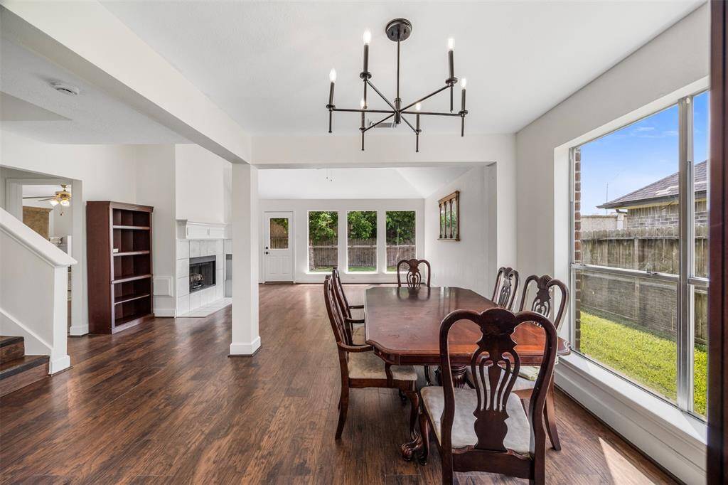 Open dining and family area featuring large windows and wood floors.