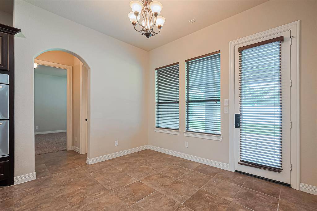 In the cozy,12x8 breakfast room, hangs a five bulb, oil-rubbed bronze chandelier much like in the dining room. Floors are lined with 18x18 tiles. Windows overlook the covered entertaining area.
