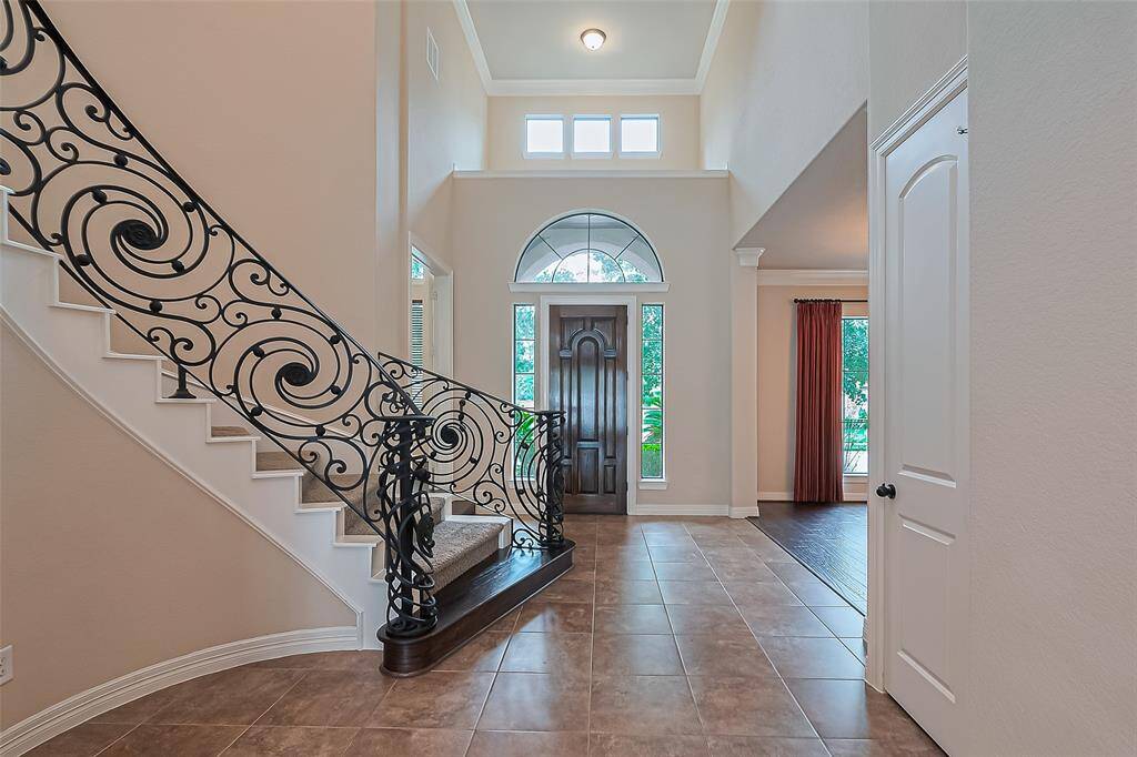 Entryway into the home is through an 8 foot, solid oak door leading into a spacious, 9x7 foyer with 20 foot ceilings and a sophisticated, custom designed railing on the sweeping staircase.