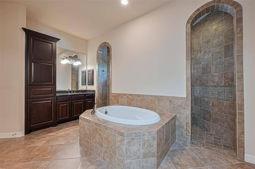 Come and relax in the gorgeous 6 foot soaking jacuzzi tub with tile surround in the primary bathroom.