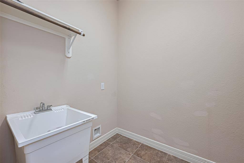 1st floor laundry room with built-in shelving, and utility sink.