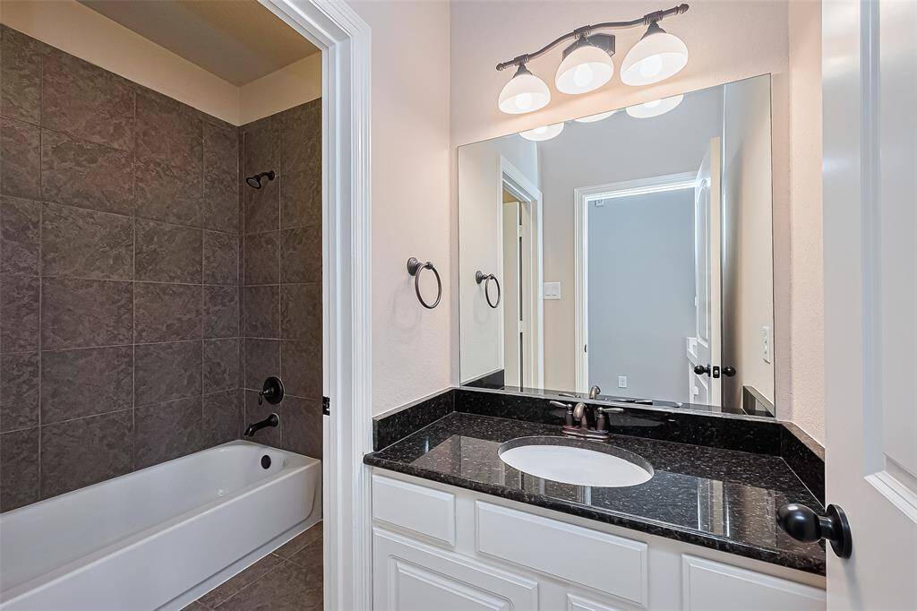 The second upstairs bathroom is a Hollywood bath with Kohler sink with Moen oil-rubbed bronze hardware and a granite countertop. Also, a walk-in closet and a furniture piece vanity.