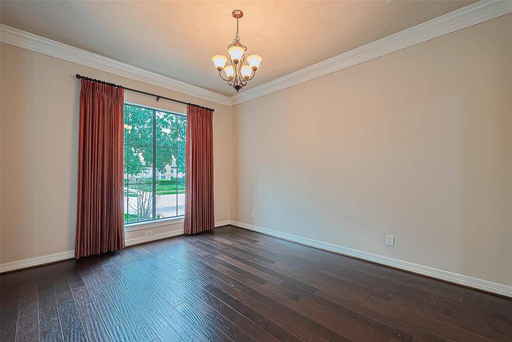 Adjacent to the foyer is the dining room, where you will find a lovely, 5 bulb oil-rubbed bronze chandelier. Floors are a 4" distressed oak. Also notice the double crown molding and deep base boards.