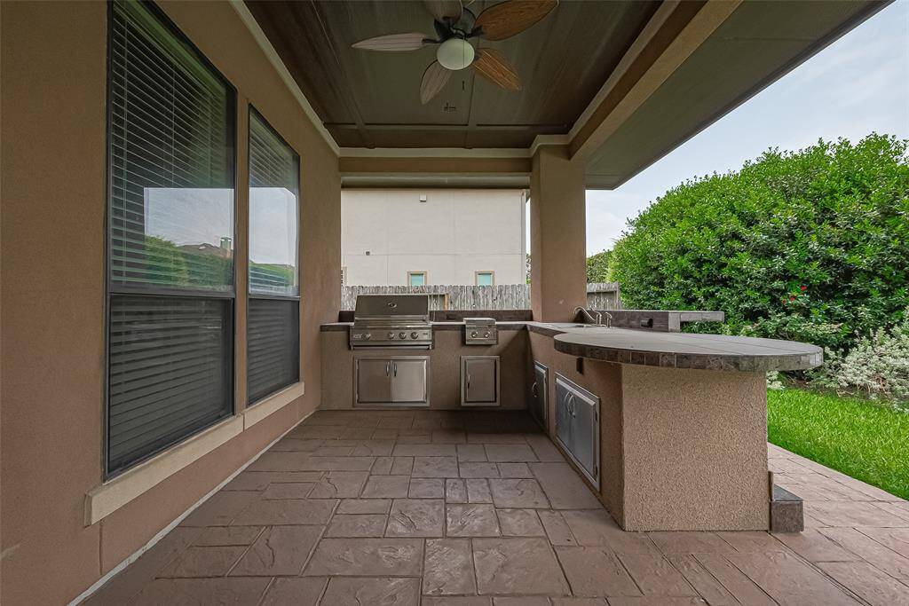 A summer kitchen with 36" grill, 2 gas burners, sink and extended gas line plug-in. Also, granite tile countertop, stamped concrete, stucco wrapped columns and also wired for 2 outdoor speakers.