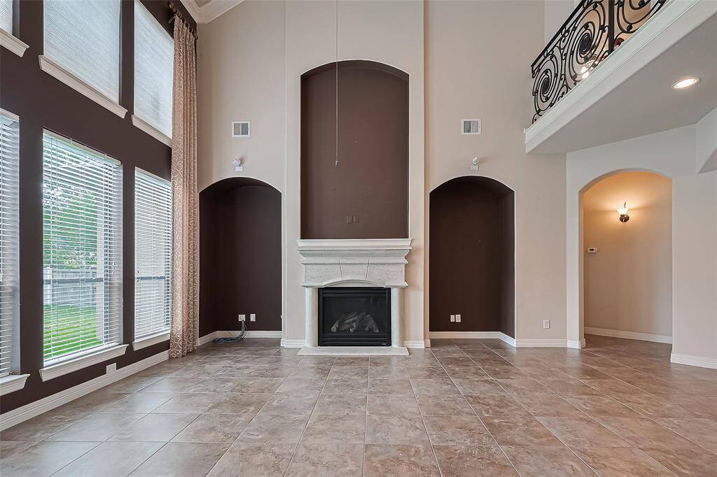 On either side of the fireplace, two elegant arched cut-outs are symmetrically positioned. These architectural features add depth and character to the space, possibly serving as built-in niches or shelving areas.